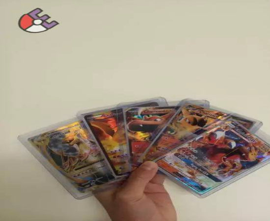A hand holding several Pokémon TCG cards, with visible images and text on the cards.